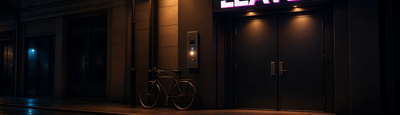The club front door at night with a pink neon sign and the intercom.
