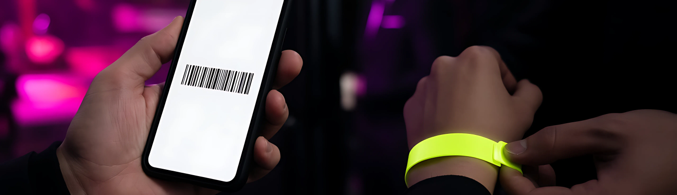 A hand holding a phone with a ticket on screen in front of a glowing club door.